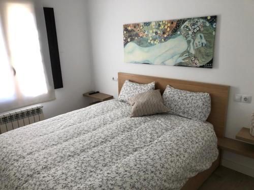 a bedroom with a bed and a painting on the wall at casa bilborazin in Albarracín