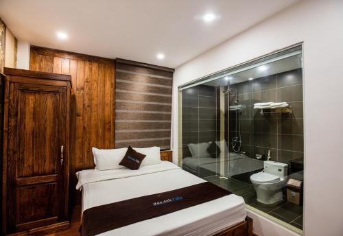 a bedroom with a bed and a shower and a toilet at Bảo Anh Villa Đà Lạt in Da Lat