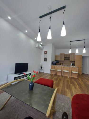 a living room with a table and chairs and a kitchen at Urban home apartments in Bihać