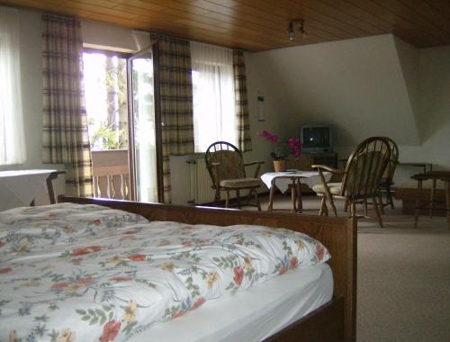 a bedroom with a bed and a table and chairs at Pension Stiegelmeier in Winterberg