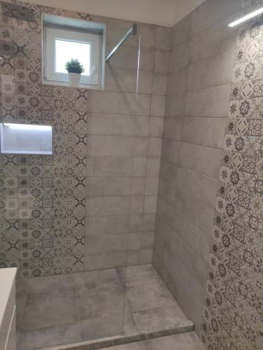 a bathroom with a shower with a window at Sunny Beach in Zánka
