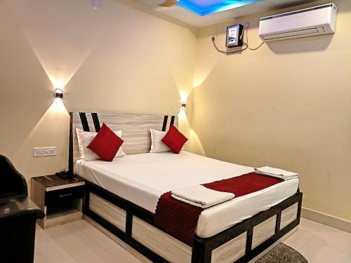 a bedroom with a bed with red pillows at Sea Wander Beach Resort in Mandarmoni