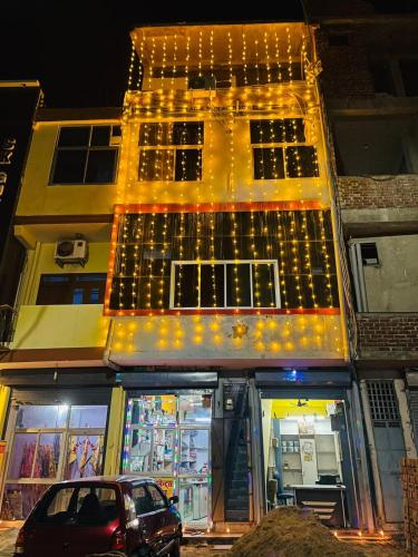 a car parked in front of a building with lights at balaji hotel & guest house in Rīngas