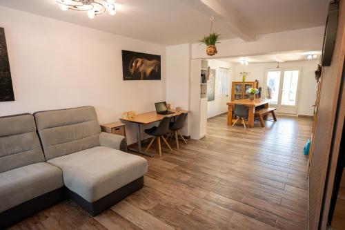un salon avec un canapé et une table avec un ordinateur portable dans l'établissement Chez Simon, au fil de l'eau, à Revel