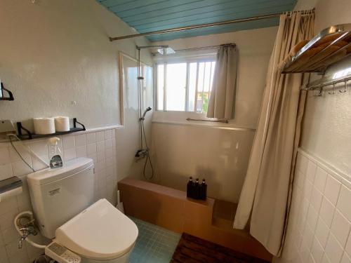 a bathroom with a toilet and a tub and a window at P-house Yumearu in Sobe
