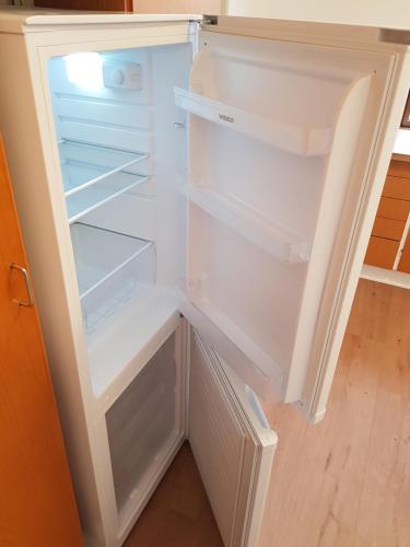 an empty refrigerator with its door open in a room at Central Apartment in Billund - 500 m from LegoHouse in Billund
