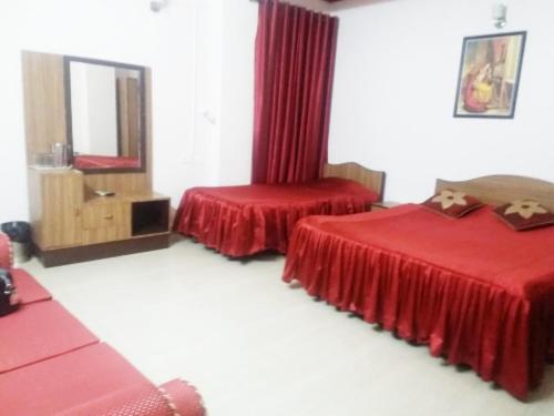 a hotel room with two beds and a mirror at Hotel Khasi Heritage in Shillong