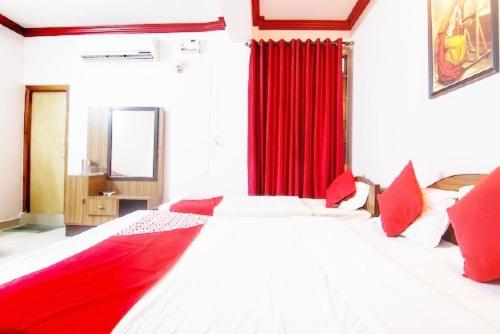 a bedroom with a large bed with red curtains at Hotel Khasi Heritage in Shillong