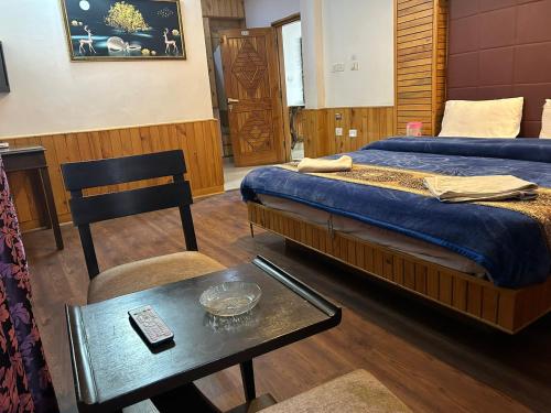 a bedroom with a bed and a table with a coffee table at Hotel green leaf kasol - by west western in Kasol