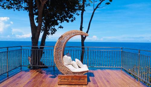 a wicker chair sitting on a deck overlooking the ocean at Seabreeze Haven Resort in Maria