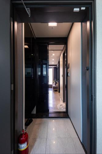 a view of a hallway with a fire extinguisher at 1 minute to the beach! Free parking! Sauna and gym in Busan