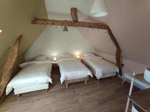 deux lits dans une chambre avec un plafond dans l'établissement La Ferme De la baie, à Favières