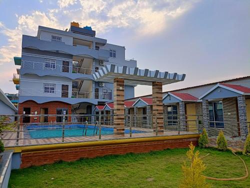 a large building with a swimming pool in front of it at Sea Wander Beach Resort in Mandarmoni