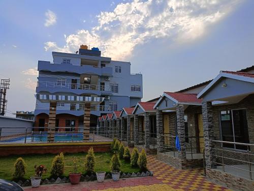 a large white building with plants in front of it at Sea Wander Beach Resort in Mandarmoni