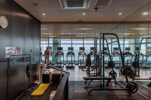 a gym with rows of treadmills and machines at 1 minute to the beach! Free parking! Sauna and gym in Busan