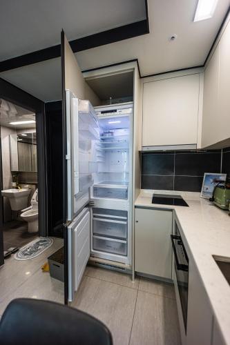 a kitchen with an empty refrigerator with its door open at 1 minute to the beach! Free parking! Sauna and gym in Busan