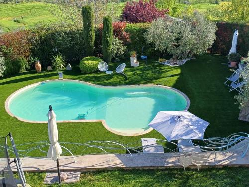 a swimming pool in a yard with an umbrella at Relaxing farmhouse in San Marino