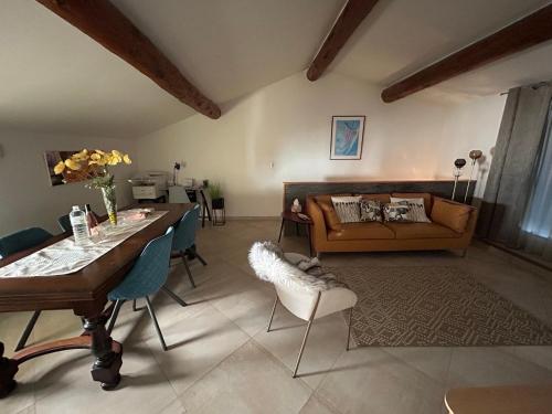 un salon avec une table et un canapé dans l'établissement Entre couleurs et senteurs, à Mirabel-aux-Baronnies