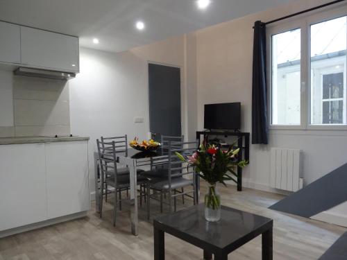 un salon avec une table et des chaises et une cuisine dans l'établissement Practical Lodging near Le Louvre, à Paris