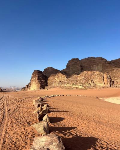 a sandy beach with rocks in the desert at wadi rum luxe tours in Wadi Rum