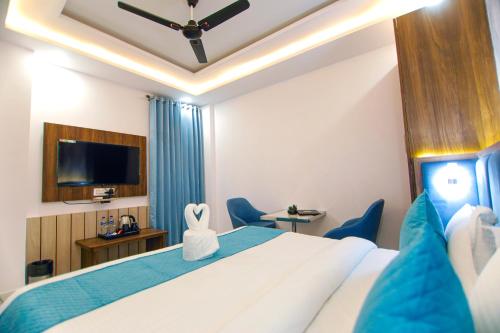 a hotel room with a bed and a flat screen tv at Paarth Grand in Haridwār