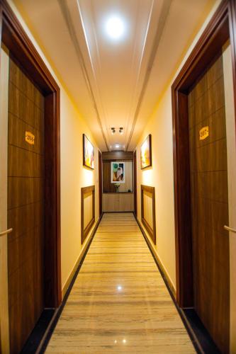 a hallway with two doors and a long corridor at Paarth Grand in Haridwār