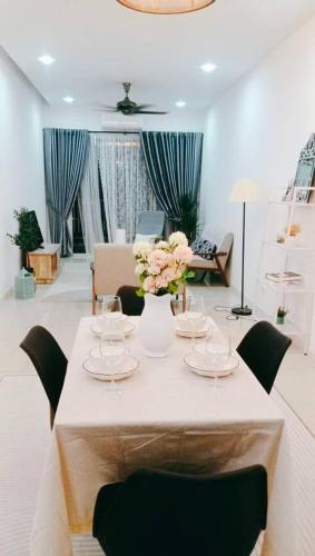 a room with a table with chairs and flowers on it at Crystal Heights Cozy House in Tupai