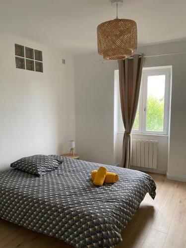 - une chambre avec un lit et 2 serviettes jaunes dans l'établissement Spacious Light Apartment, à Montélimar