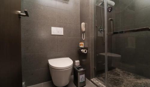 a bathroom with a toilet and a glass shower at Crystal Orange Shanghai Lingang Ocean Park Hotel in Nianbalian