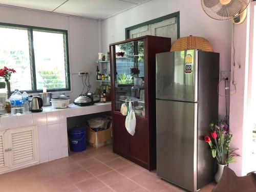 a kitchen with a refrigerator and a counter at PhimHomeStayCR in Ban Thung Ngio