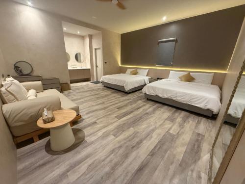a hotel room with two beds and a flat screen tv at Easy Stay Club in Xiaoliuqiu