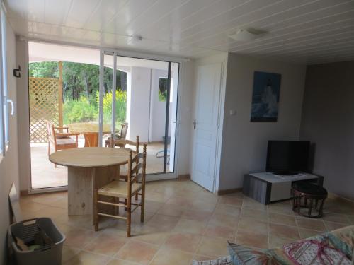 un salon avec une table et une télévision dans l'établissement Logement au calme au sein de la provence verte, à Seillons-Source-dʼArgens