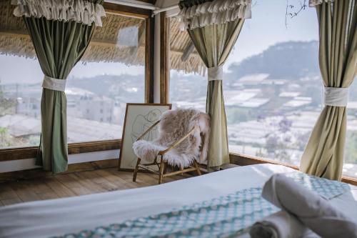 Mái Lá Homestay & Herbal Spa في دالات: غرفة نوم بسرير وكرسي في شباك