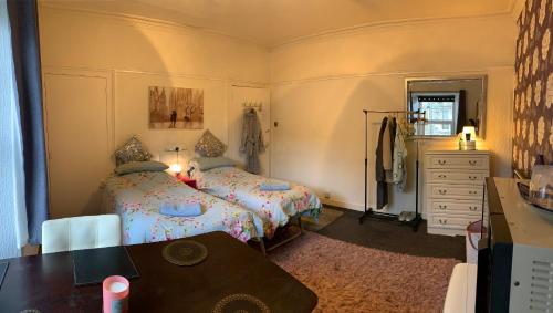 アーヴィンにあるDundonald Link, quiet & spacious twin room in town centreのベッドルーム1室(ベッド2台、ドレッサー、テーブル付)