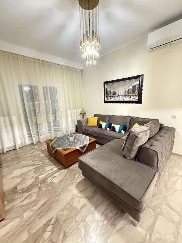 a living room with a couch and a table at Efesou Large Apartment in Néa Éfesos