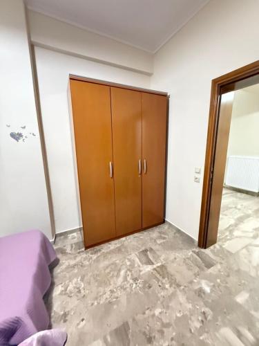 a bedroom with a wooden closet and a door at Efesou Large Apartment in Néa Éfesos