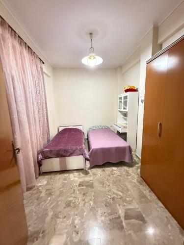 a bedroom with two beds in a room with a door at Efesou Large Apartment in Néa Éfesos