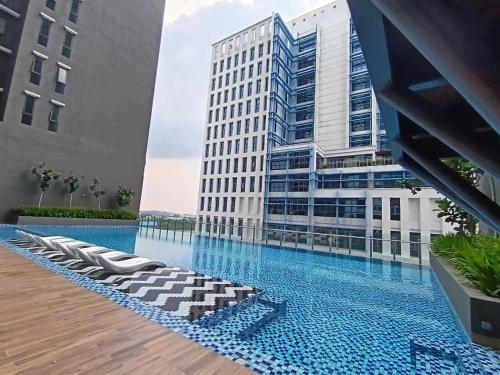 a large building with a pool in front of a building at Alinea Suites Shah Alam in Shah Alam