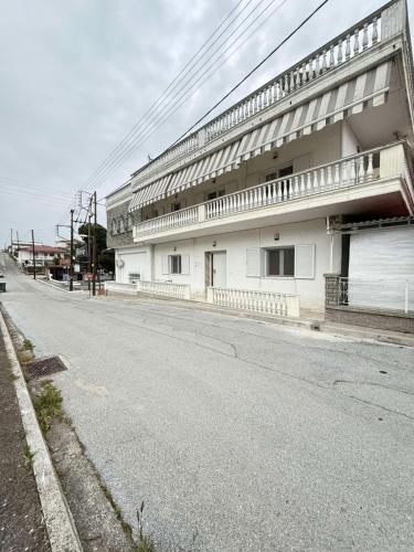 an empty street in front of a white building at Efesou Large Apartment in Néa Éfesos