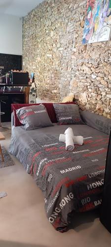 un lit dans une chambre avec un mur en pierre dans l'établissement La suite musicale, à Villeneuve-Saint-Denis