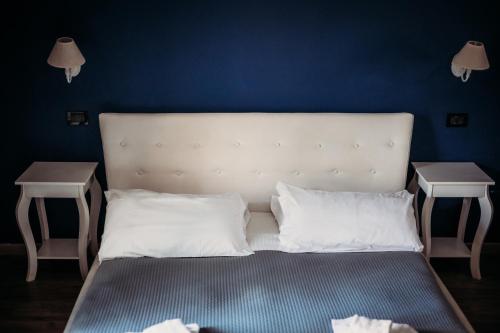 a bed with white pillows and two night stands at Hotel Domus Tiberina in Rome
