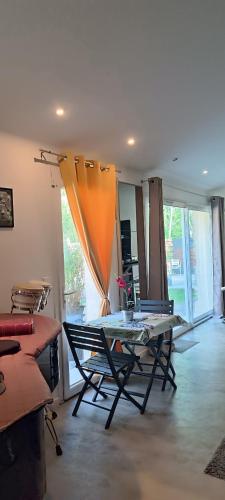 un salon avec une table et des chaises dans l'établissement La suite musicale, à Villeneuve-Saint-Denis