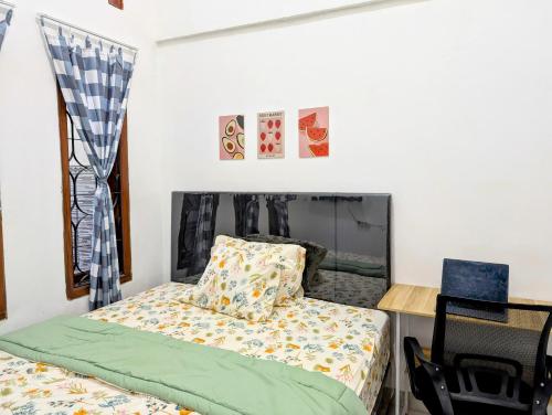 a small bedroom with a bed and a desk at Surabaya Homey Jemursari Syariah in Surabaya