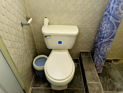 a small bathroom with a toilet and a trash can at Buenos Aires Apartments in Río San Juan