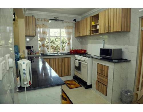 a kitchen with a stove and a microwave at Spacious Town House in Nakuru in Nakuru