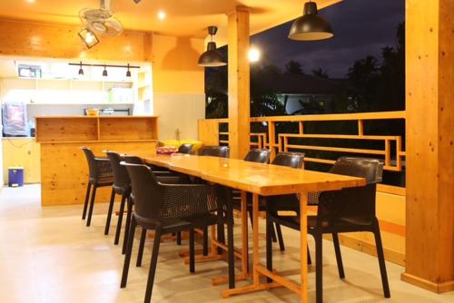 a dining room with a wooden table and chairs at Ever Blue Guest House in Mathiveri