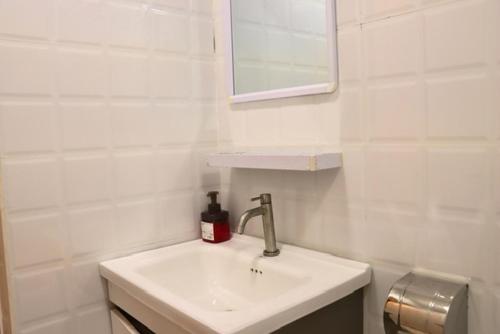a white bathroom with a sink and a mirror at Ever Blue Guest House in Mathiveri