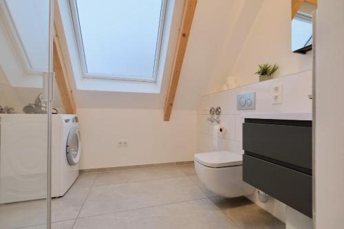 a bathroom with a toilet and a sink and a window at Brandneues Stadtglanz Apartment in Stuttgart
