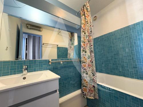une salle de bain avec un lavabo et une douche dans l'établissement front de mer 2 chambres parking quartier corniche, à Sète