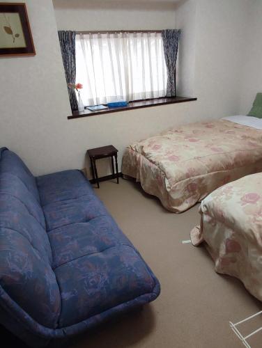 a living room with a couch and two beds at 北軽井沢 あさま1155 in Tsumagoi